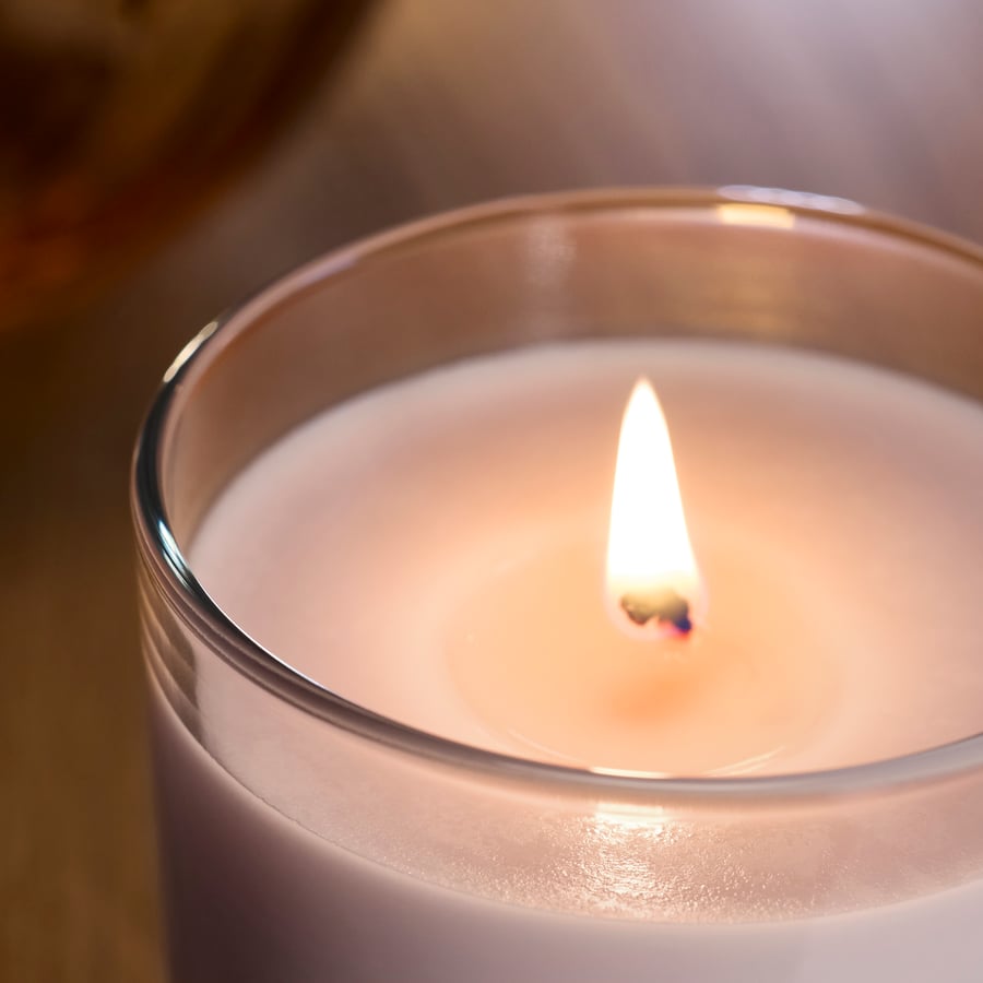 Bougie parfumée dans verre, fleurs roses rose pâle